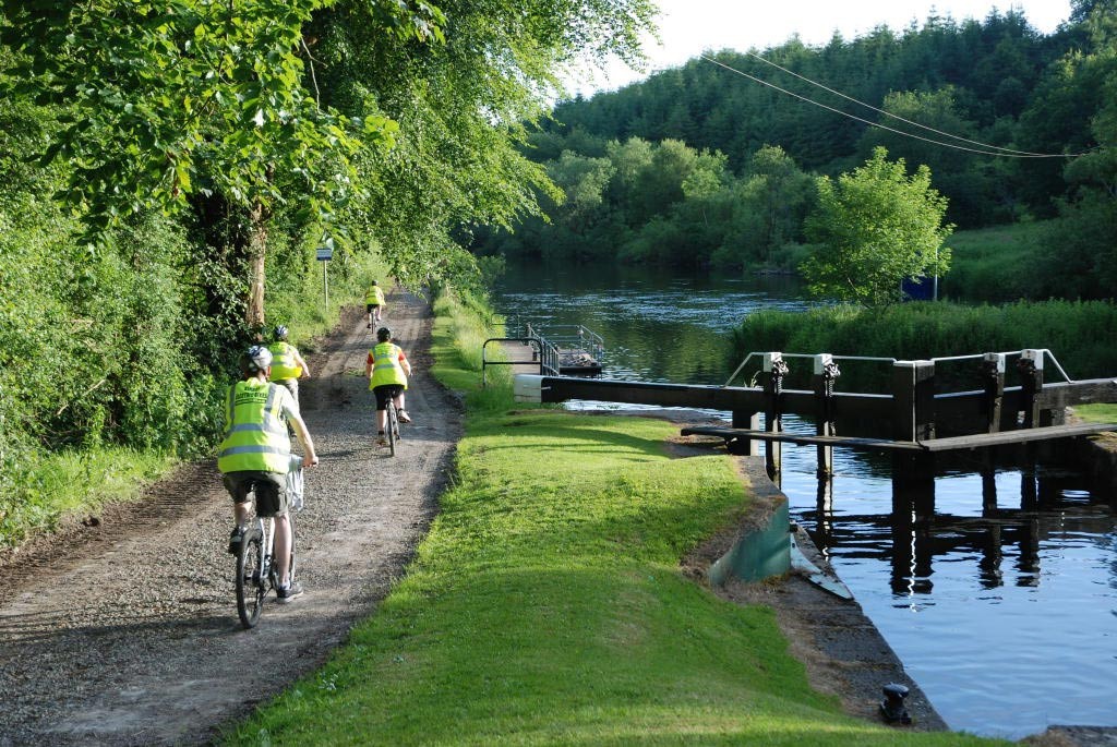 women on bike beside a river