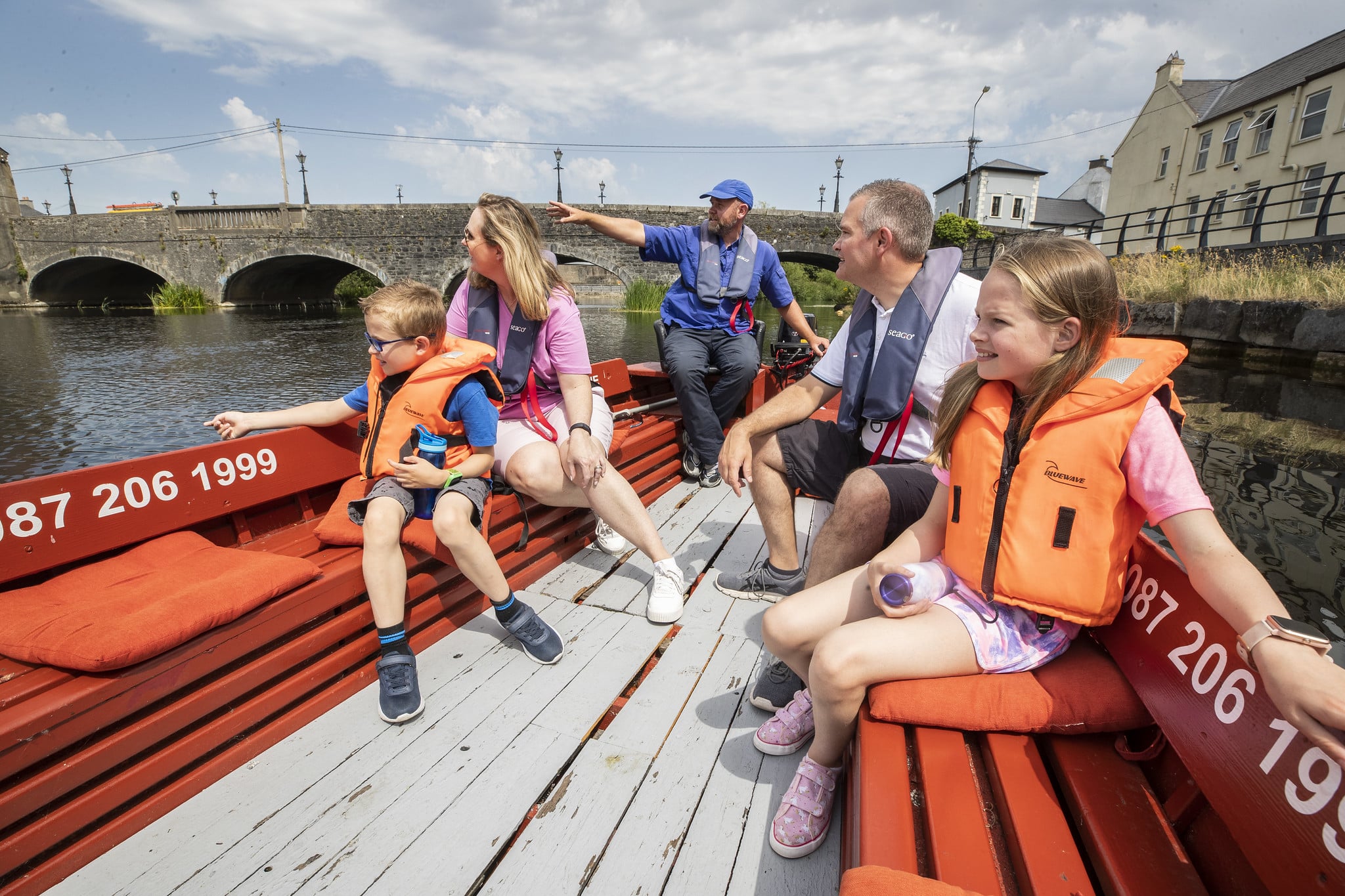 A family on a guided tour aboard a boat on the river Slaney.